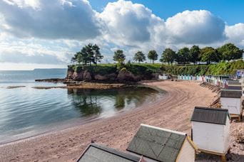 beach huts next to a beach