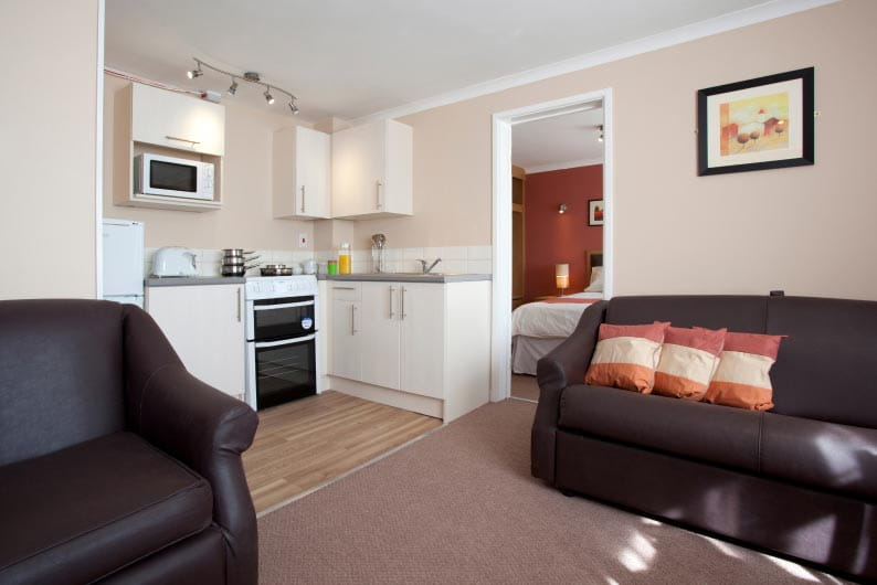 holiday apartment sitting room with sofas and kitchenette