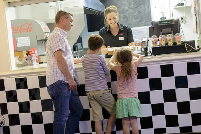 Father and two children being served at the takeaway at Torquay Holiday Park