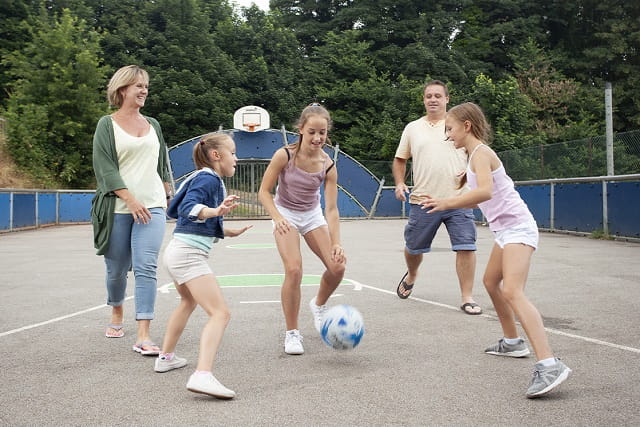 A family playing in outdoor multi sports court at Torquay Holiday Park