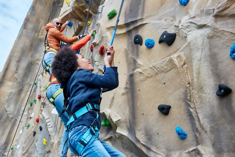 children climbing a climbing wall