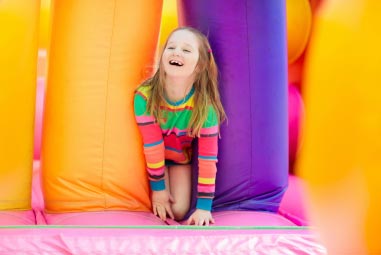 a child playing in a bouncy castle