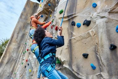 children climbing on a climbing wall