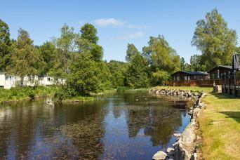 Holiday park caravans in woodland by a lake