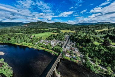 Small village surrounded by lush land and a loch