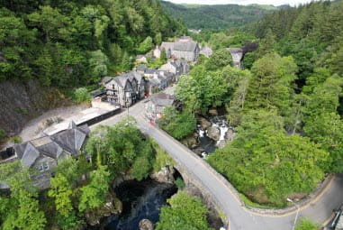 Arial view of road leading to tree-lined scenic village