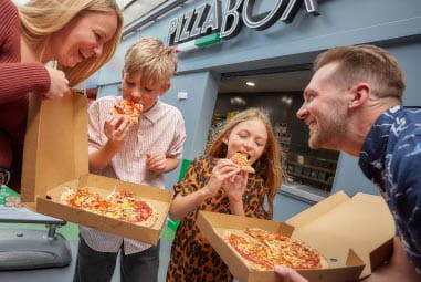 Family enjoying pizza at Pizza Box