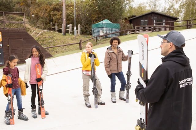 People waiting to ski on the dry ski slope at Warmwell with an instructor