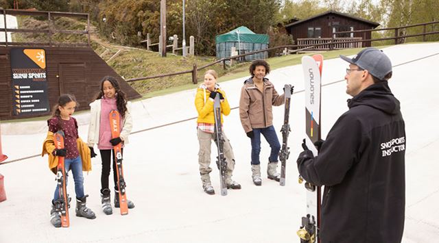 family being taught be a ski instructor on a ski lesson