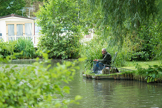 A man fishing in the fishing lake at Weeley Bridge Holiday Park