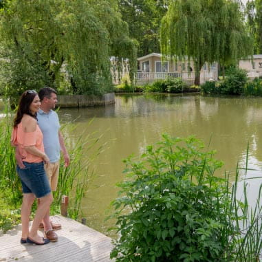 a couple standing by a lake