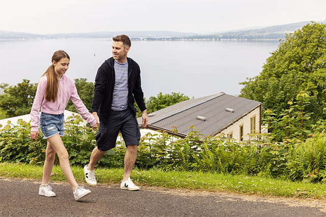 A couple going for a stroll with a beautiful view of the loch at Wemyss Bay Holiday Park