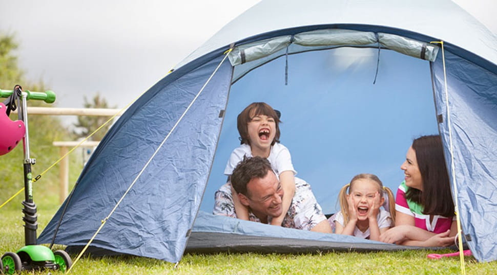family poking their heads out of a tent