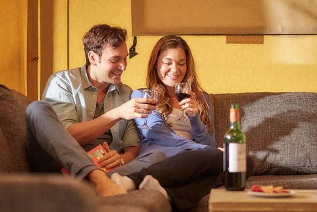 couple relaxing on a sofa with a glass of wine