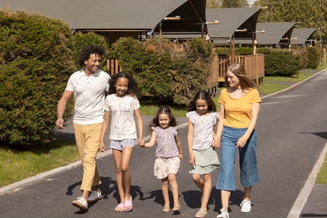 a family of five walking down a path in a Dorset holiday park