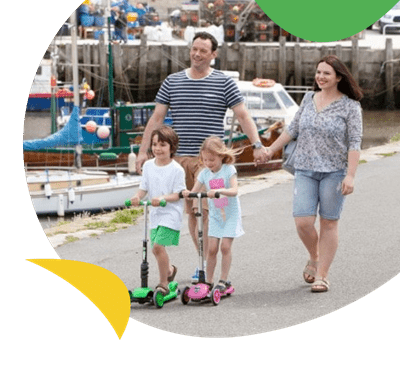 Family walking along harbour at West Bay