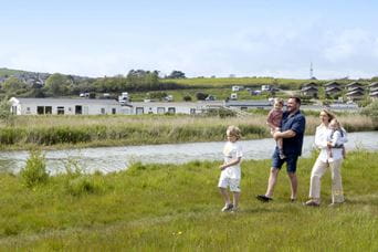 a family strolling along the side of a river
