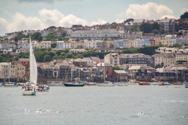 Sailing boats in the harbour, overlooked by the colourful town of Falmouth in Cornwall