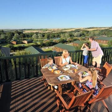 a family sitting on the patio outside their caravan