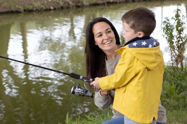 mother and son fishing by a lake at White Acres Holiday Park