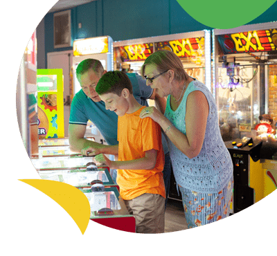 A family playing in the arcades at White Acres Holiday Park