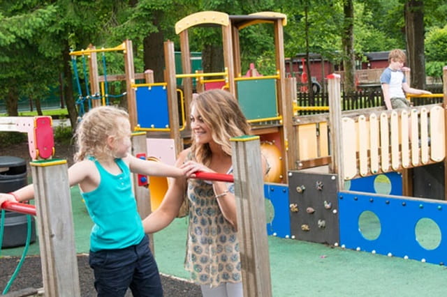 Kids playing in the playground at White Cross Bay Holiday Park