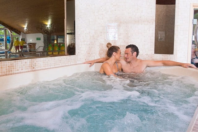 A couple relaxing in the spa bath at White Cross Bay