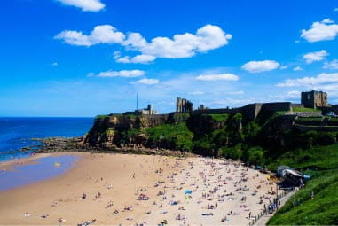 a sandy beach with a castle behind it