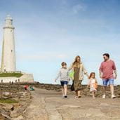 a family walking to a lighthouse