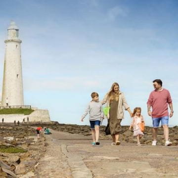 a family walking to a lighthouse