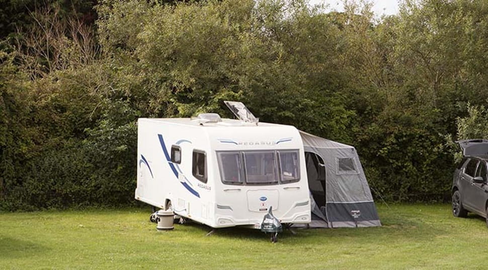 A touring caravan and awning pitched up on the grass