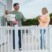 Couple with baby having a hot drink on a terrace