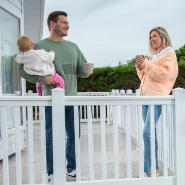 Couple with baby having a hot drink on a terrace