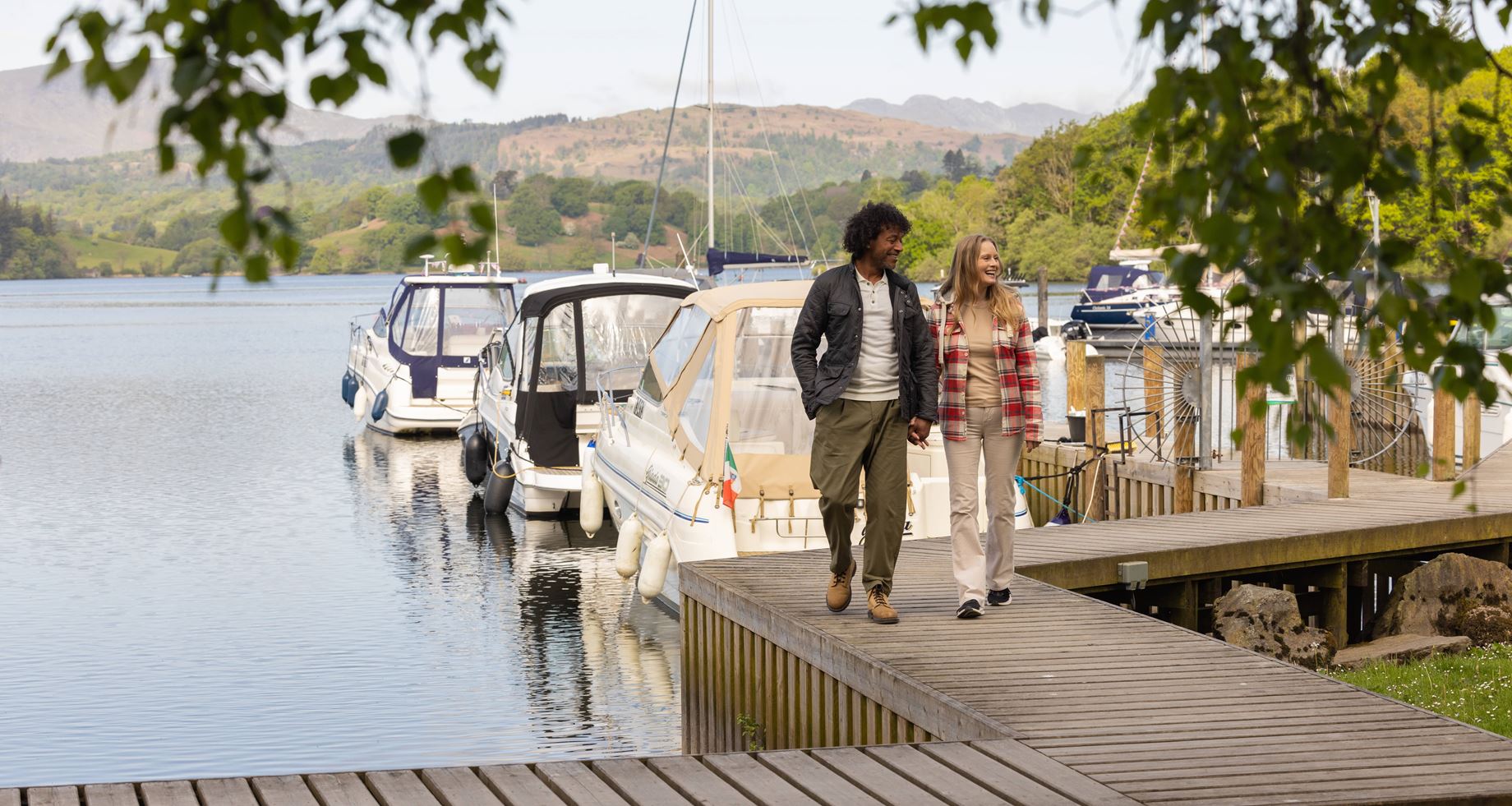 couple walking hand in hand by a lake