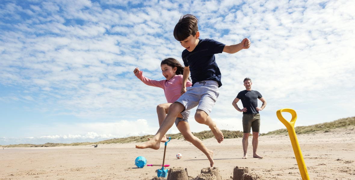 Kids running and jumping in the sand