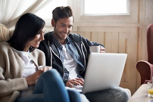 Couple sat on laptop looking at Parkdean caravans