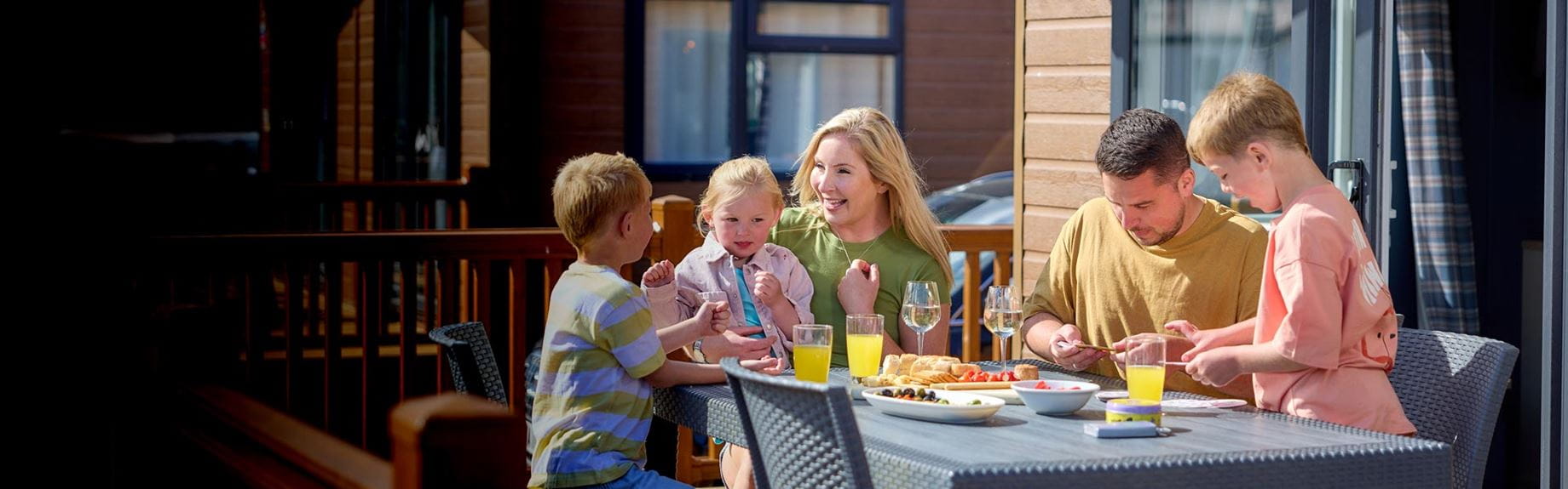 Family on decking with breakfast