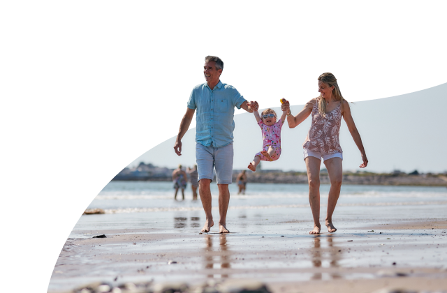 Family of three walking on the beach