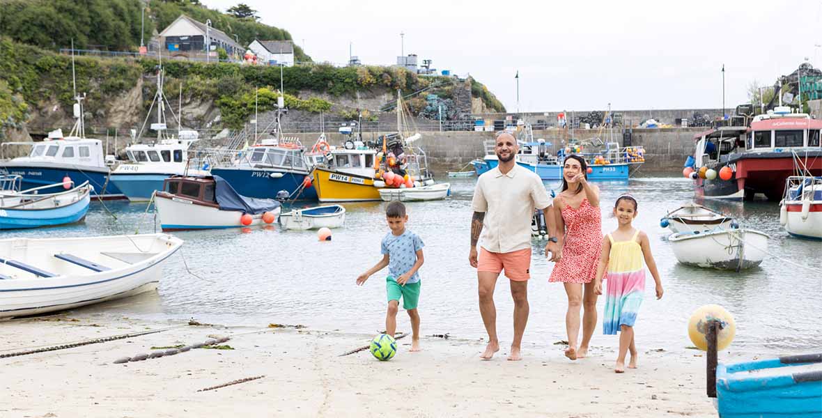 A family walking on the beach in Newquay Harbour