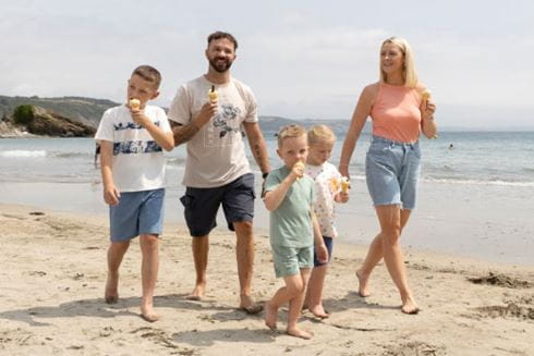 A family eating ice creams at the beach in Cornwall