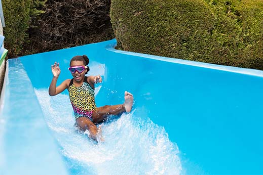 A girl sliding down a waterslide at a Parkdean Resorts holiday park in Cornwall