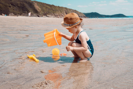 A girl building sandcastles on a Cornish beach
