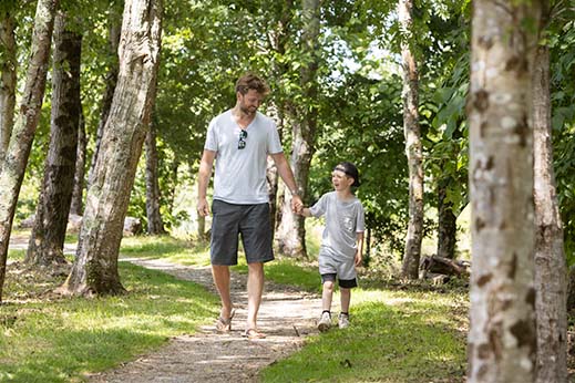 A father and son walking through the woods in Cornwall on a holiday
