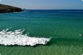 Surfers lining up to catch waves at Fistral Beach in Cornwall