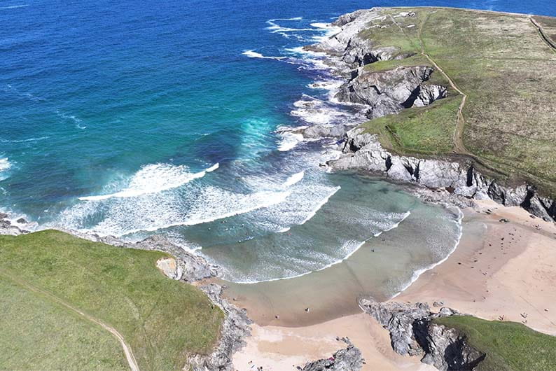 An aerial view over Polly Joke Beach in Cornwall