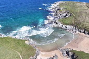 An aerial view over Polly Joke Beach in Cornwall