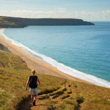 Woman walking down towards the beach