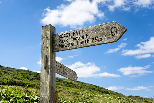 A directions sign on the South West Coast Path in Cornwall