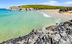 Blue waters of Porth Joke Beach in Cornwall