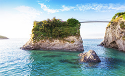 A rocky outcrop with a footbridge connecting it to the land